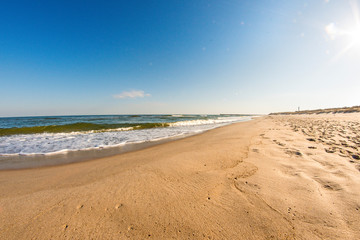 Fototapeta na wymiar lonesome beach of the Baltic Sea with blue sky and surf