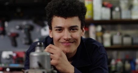 4K Close up panning shot of young smiling mechanic in auto repairs shop