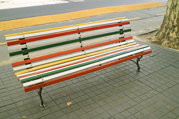 Empty Multi-colored Wooden Bench on the Street Side Footpath 