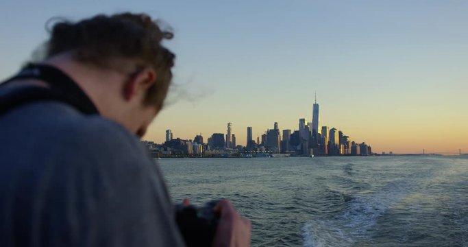 Man Photographing Sunset On Hudson River Moving Away From Incredible New York Sunset And Beautiful Skyscrapers and Iconic Skyline In NYC
