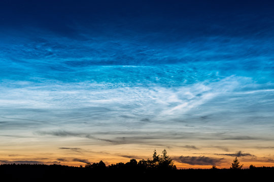 Rare Noctilucent clouds also known as silver clouds in the night sky in a rural scenery outside the city. These phenomenon clouds consist of ice crystals and are visible during astronomical twilight
