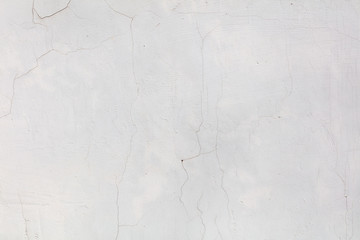 White wall with cracked plaster as abstract background