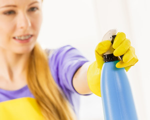 Girl cleaning window at home