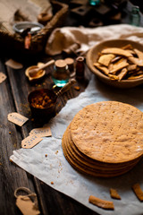 Homemade stack of baked layers of Russian traditional honey cake on baking paper on wooden rustic table 
