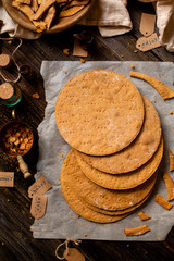 Overhead shot of homemade baked layers of Russian traditional honey cake on baking paper on wooden rustic table