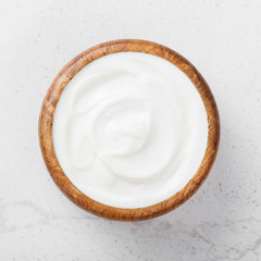 Sour cream in a wooden bowl .