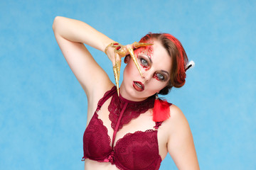 Portrait waist-up against a blue background of a pretty young brunette woman with beautiful makeup, with gold jewelry on her hand. Art, beauty, great makeup. Shows emotions.