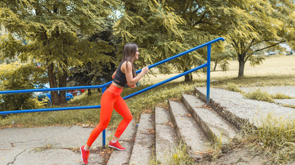 Fototapeta premium Przekonana, młoda kobieta sportowca, jogging na świeżym powietrzu. Bieganie w parku miejskim. Kobieta biegacz poza jogging. Sportowa dziewczyna w sportowej biegania, biegania i treningu na świeżym powietrzu