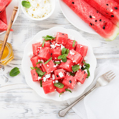 Summer salad of watermelon, feta cheese and mint leaves. on white wooden background