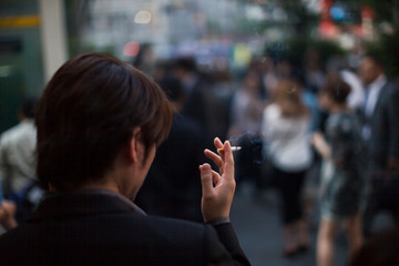 路上でタバコを吸う男性