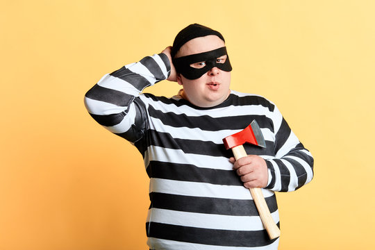 pensive thoughtful murder with hand on his head going to commit crime, making plan, idea, isolated yellow background, studio shot.to kill or nt to kill