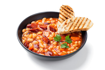 Stewed white beans with smoked sausage and tomato sauce. Bean soup. isolated on white background 