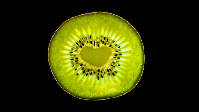 Isolated kiwi fruit with a heart-shaped core on black background