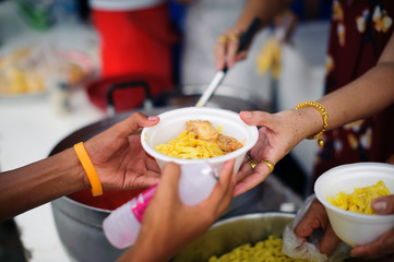 The concept of society in sharing each other : Hands of beggars accepting food from the hands of...