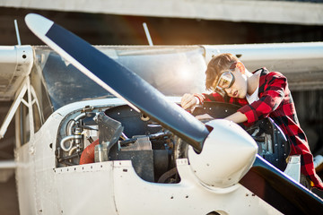 boy helps his father with checking up service for their private small propeller air jet, works...