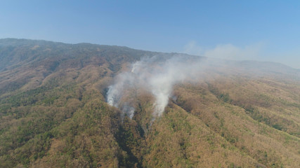 aerial view forest fire smoke on the slopes hills. wild fire in tropical forest, Indonesia. natural disaster fire in Southeast Asia