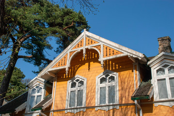 Fassade und Giebel eines alten gelben Holzhauses in Jurmala, LEttland