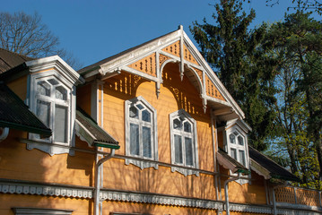Fassade und Giebel eines alten gelben Holzhauses in Jurmala, LEttland