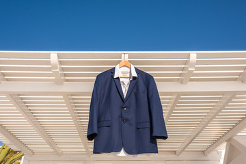 Groom Blue Suit hanging on the House - wedding day Getting ready