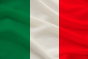 The national flag of the country of Italy on gentle silk with wind folds, travel concept, immigration, politics, copy space, close-up