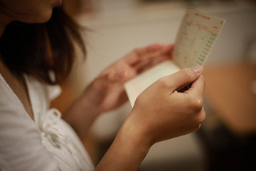 通帳を見て悩む女性