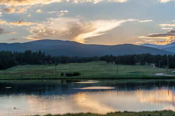 Sunset over a small Lake in the Colorado Rocky Mountains, known as Los Lagos Reservoir Number three. Near Kelly Dahl Campground and the Town of Nederland, CO.