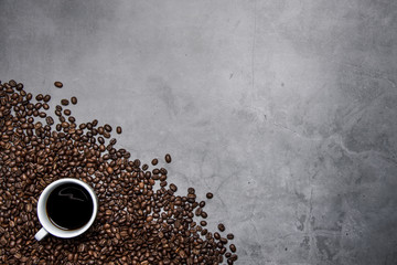 cup of coffee and beans on concrete background