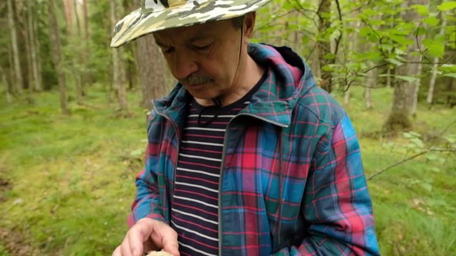 Man explorer searching direction with compass in summer forest