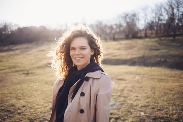 Happy smiling young woman with long curly hair