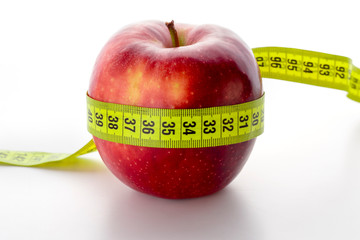 Big red apple with measuring centimeter on a white background