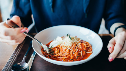 Young woman eating Italian pasta