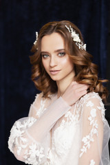 Fototapeta premium Wedding. Portrait romantic bride with beautiful hairstyle. Luxurious white wedding dress. Bridal wedding hairstyle with jewelry. Elegant hair accessorie. Studio indoor photo. 