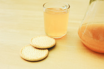 A cup of juice with cookies on the wooden table