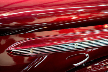 Close Up Of Chrome Decoration On Metallic Red Classic Car