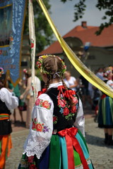 Girl in traditional folk costume from Lowicz region, Poland, on her back, during Corpus Christi...