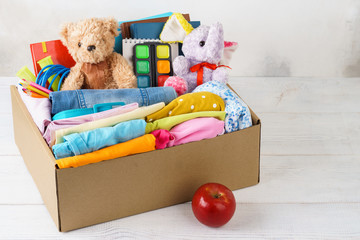 Colorful casual clothes, stationery and toys in a box.