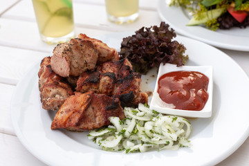 pieces of shashlik with ketchup and onions on a plate