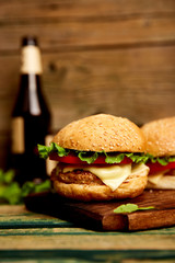 Craft beef burger  on wooden table isolated on black background..Street food, fast food. Homemade juicy burgers with cheese and  on the wooden table. Copy space.