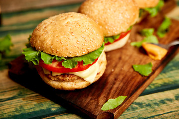 Craft beef burger  on wooden table isolated on black background..Street food, fast food. Homemade juicy burgers with cheese and  on the wooden table. Copy space.