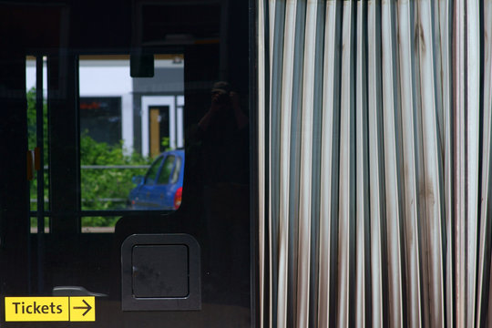 Die Nahaufnahme der Karosse eines Gelenkbusses mit einem Faltenbalg sowie Fenstern. .