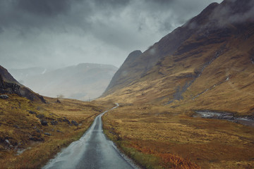 Beautiful scenic road in Glen Etive, Glen Coe Scotland. Skyfall landscape in rainy foggy weather. - obrazy, fototapety, plakaty