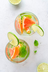 Glass of cool infused water with fresh grapefruit, lime and mint, (lemonade, cocktail). Detox drink, health care, fitness, diet concept.
