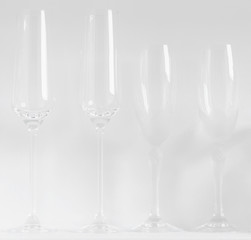 Champagne glasses and flutes against a white background. Minimal low contrast white on white concept.