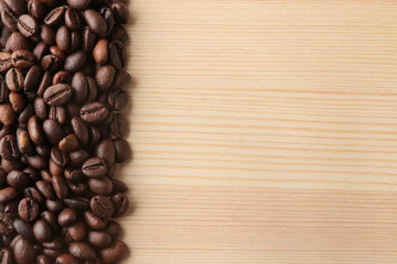 roasted coffee beans on a natural wooden table. Frame of coffee beans Robusta, Arabica. top view. space for text