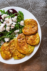 Pancakes with greek salad on white plate