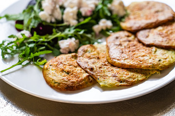 Pancakes with greek salad on white plate