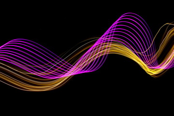 Long exposure photograph of neon purple and metallic gold colour in an abstract swirl pattern against a black background. Light painting photography.
