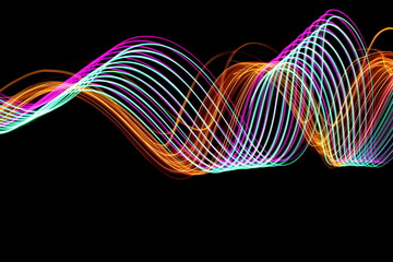 Long exposure photograph of neon purple, green and metallic gold colour in an abstract swirl...