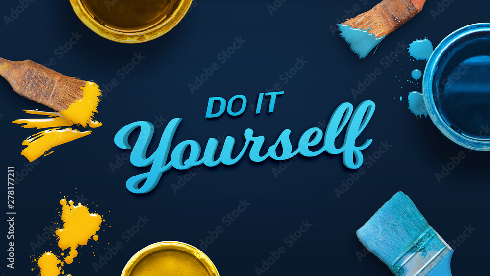 Poster do it yourself text surrounded by color brushes and boxes on the blue surface. top view, flat lay, c