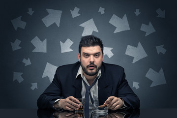 Drunk disappointed man sitting at table with arrows around